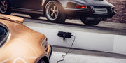 CTEK CS ONE Gen 2 Batterieladegerät in einer Garage neben einem Sportwagen während des Ladevorgangs
