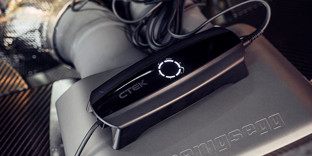CTEK CS ONE Gen 2 Batterieladegerät im Motorraum eines Fahrzeugs während des Batterieladevorgangs
